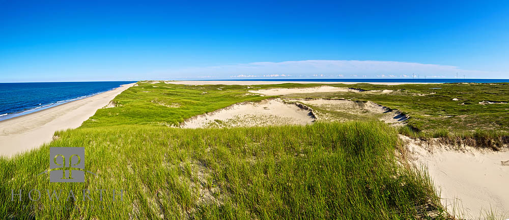 A panoramic image showing the vast, flat, grass and sand dunes of Sable Island