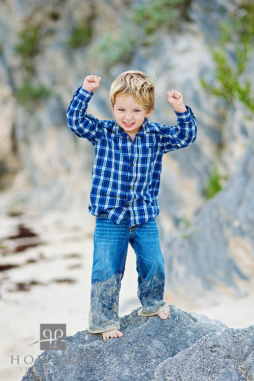 Young boy climbing on the rocks after a day of playing