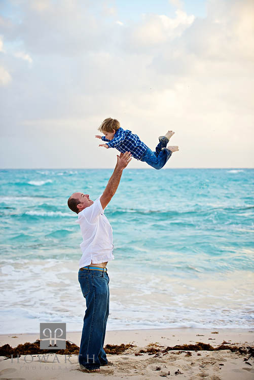 Father throwing his young son in the air and reaching out to catch him