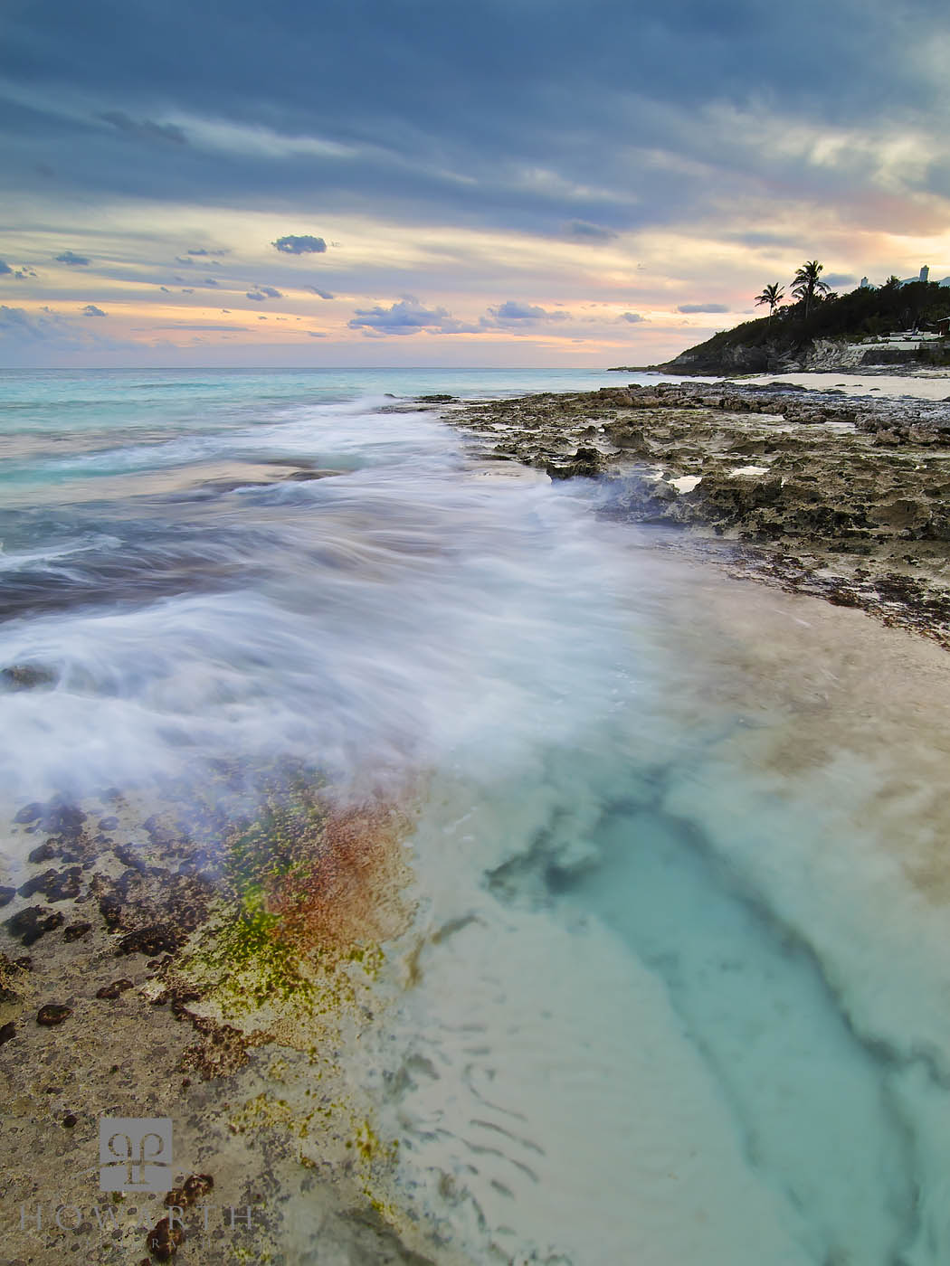 An evening scene at Grape Bay with an incoming wave across the rocks. Read more about this is image here