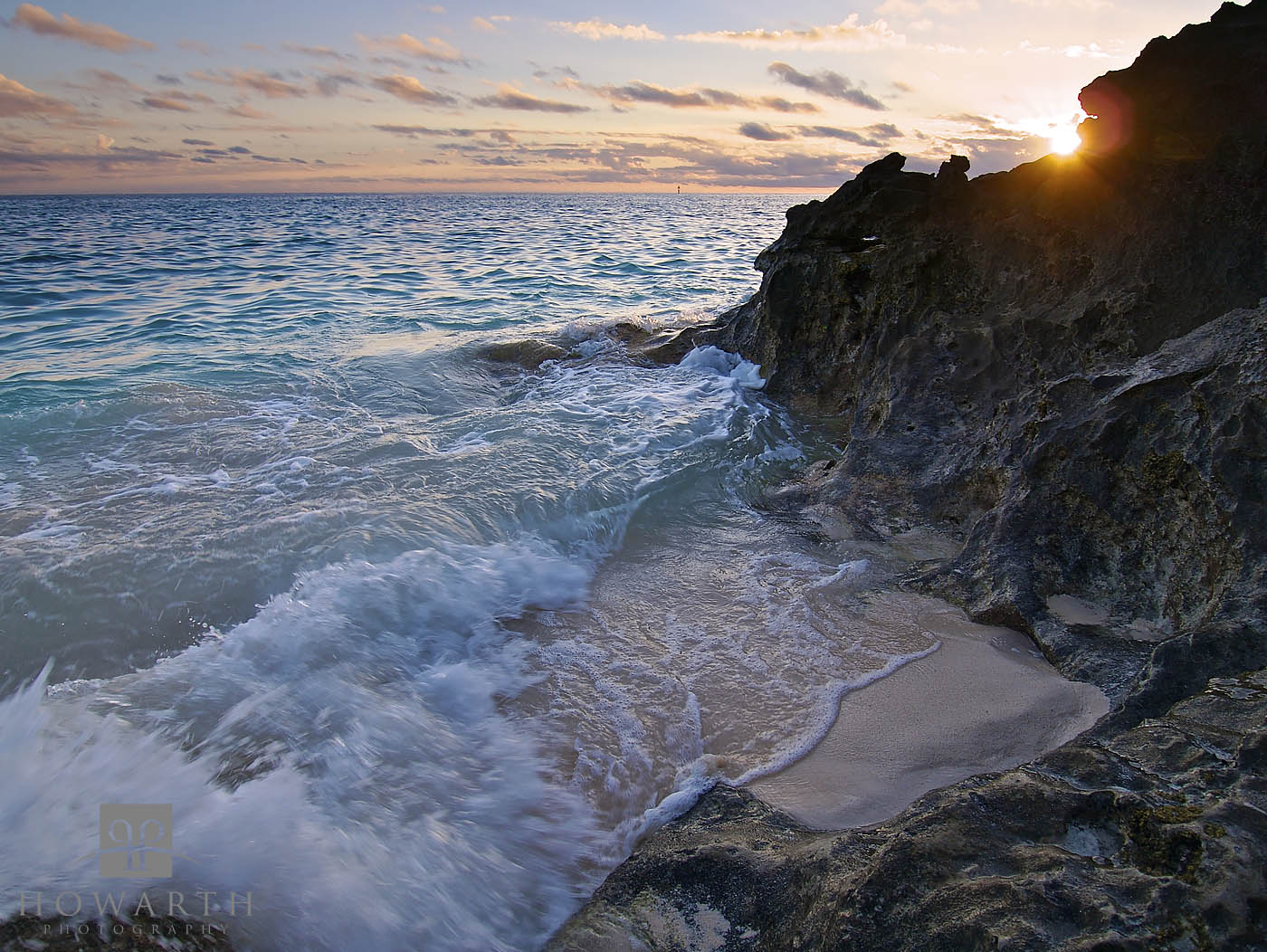 The sun dips over the rocks as it sets