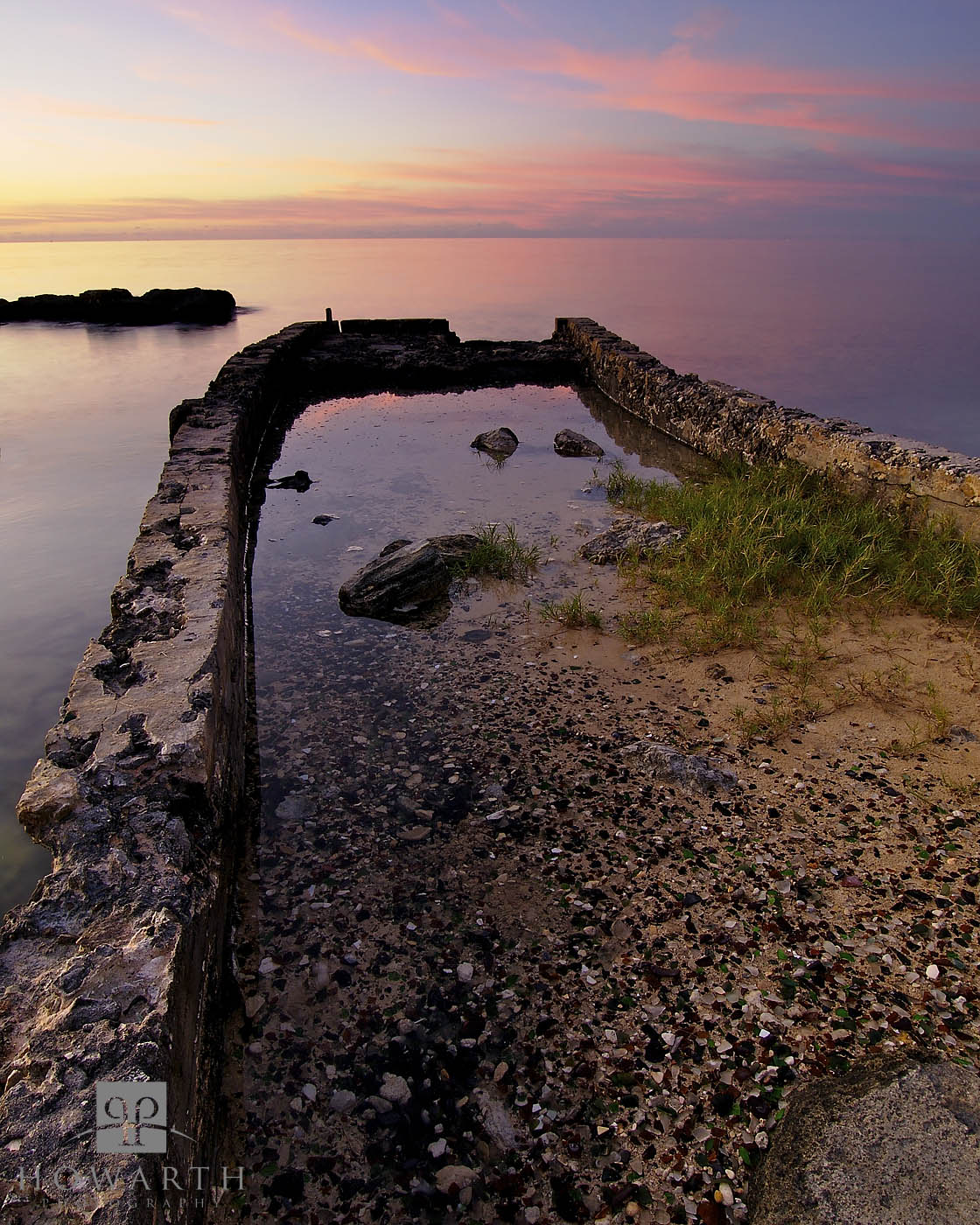 The remnants of an old pier just out into the setting sun